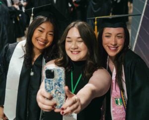 Marketing interns Gracie, Morgan and Victoria smile together for a photo at Marshall University's spring commencement
