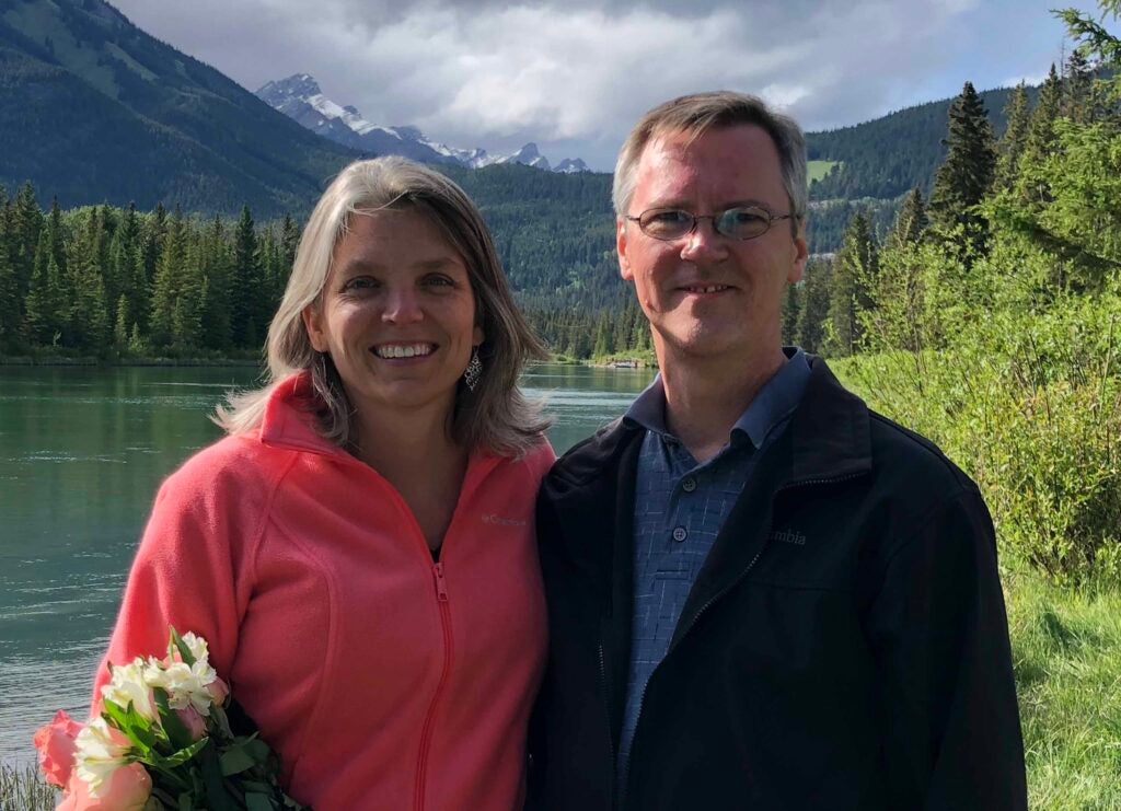 Lea Ann Parsley-Davenport and her husband Ryan Davenport smile together in front of a mountain background