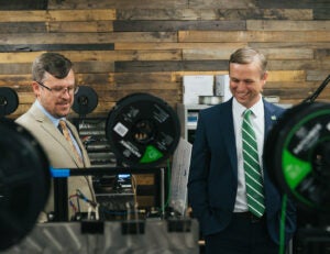 Derek Scarbro and Brandon Dennison watch a 3D printer in action at the Marshall Advanced Manufacturing Center