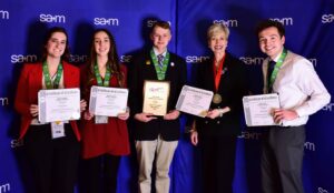 Students hold award certificates at the 2023 SAM International Business Conference