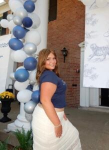 Emily Price smiles in front of a balloon display outside of her sorority 