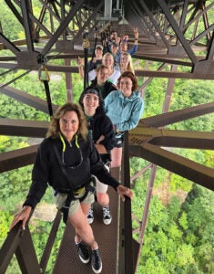 Alys Smith smiles with students in the BOLD Women's Leadership Program from under the New River Gorge Bridge 