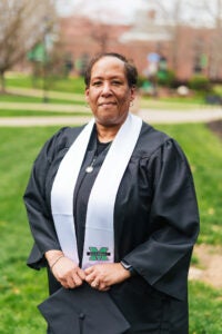 Toni Wooding wears her graduation regalia while standing outside