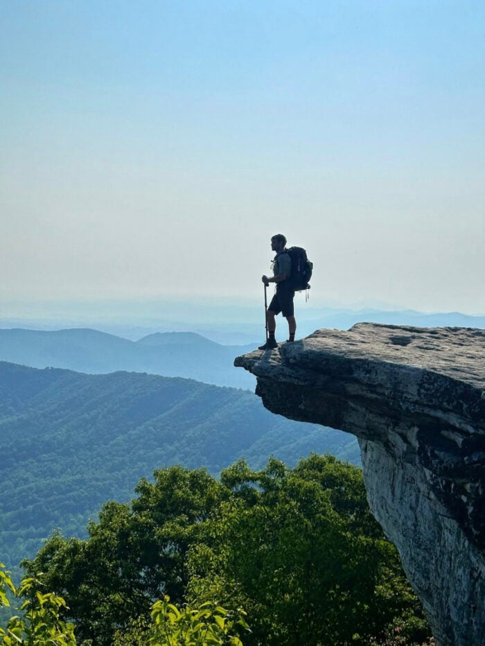 Daniel Parlock at McAfee Knob in Catawba, Virginia surrounded by a beautiful mountain background