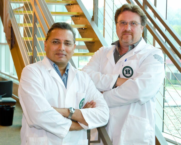 Marshall University's Dr. Valluri and Dr. Claudio smile together in their white coats
