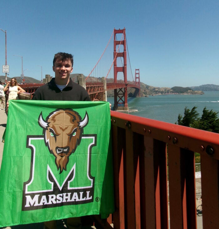 Brandon Anderson holds a Marshall Flag in front of the Golden Gate Bridge in San Francisco