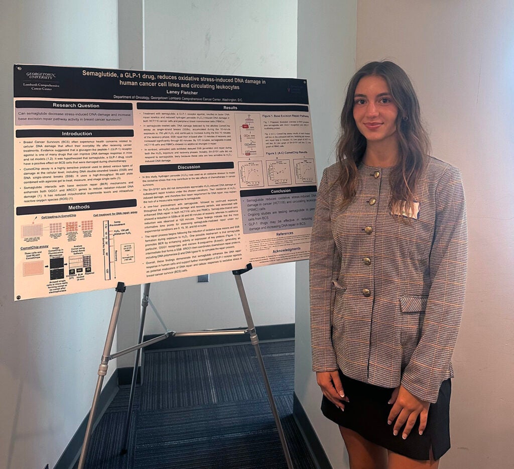 Laney Fletcher stands next to a research poster