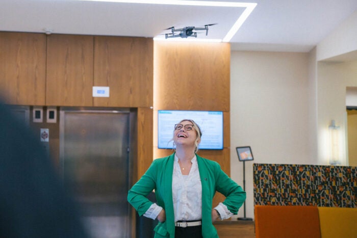 Lakan Sheets smiles while watching a drone fly above her during a cyber event