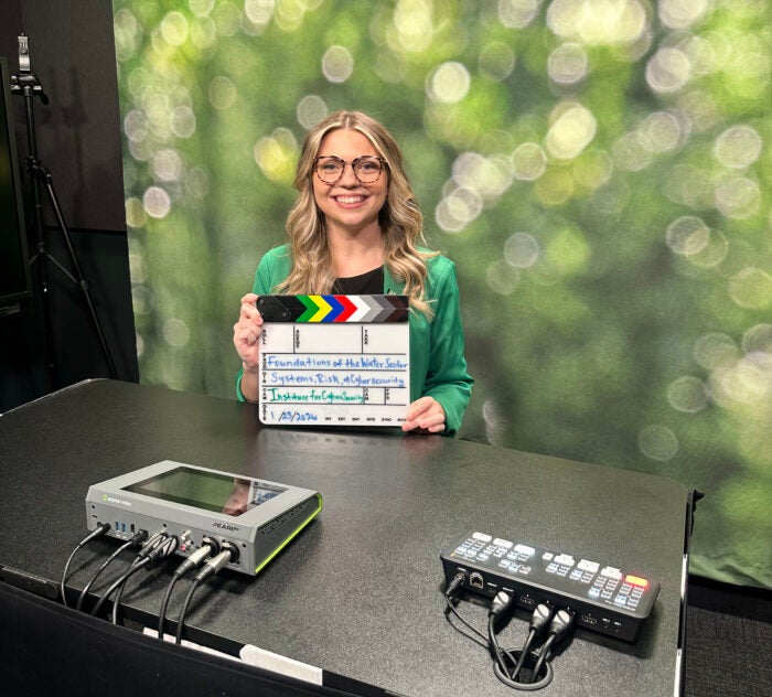 Lakan Sheets holds a scene clapper while recording content for a microcredential course