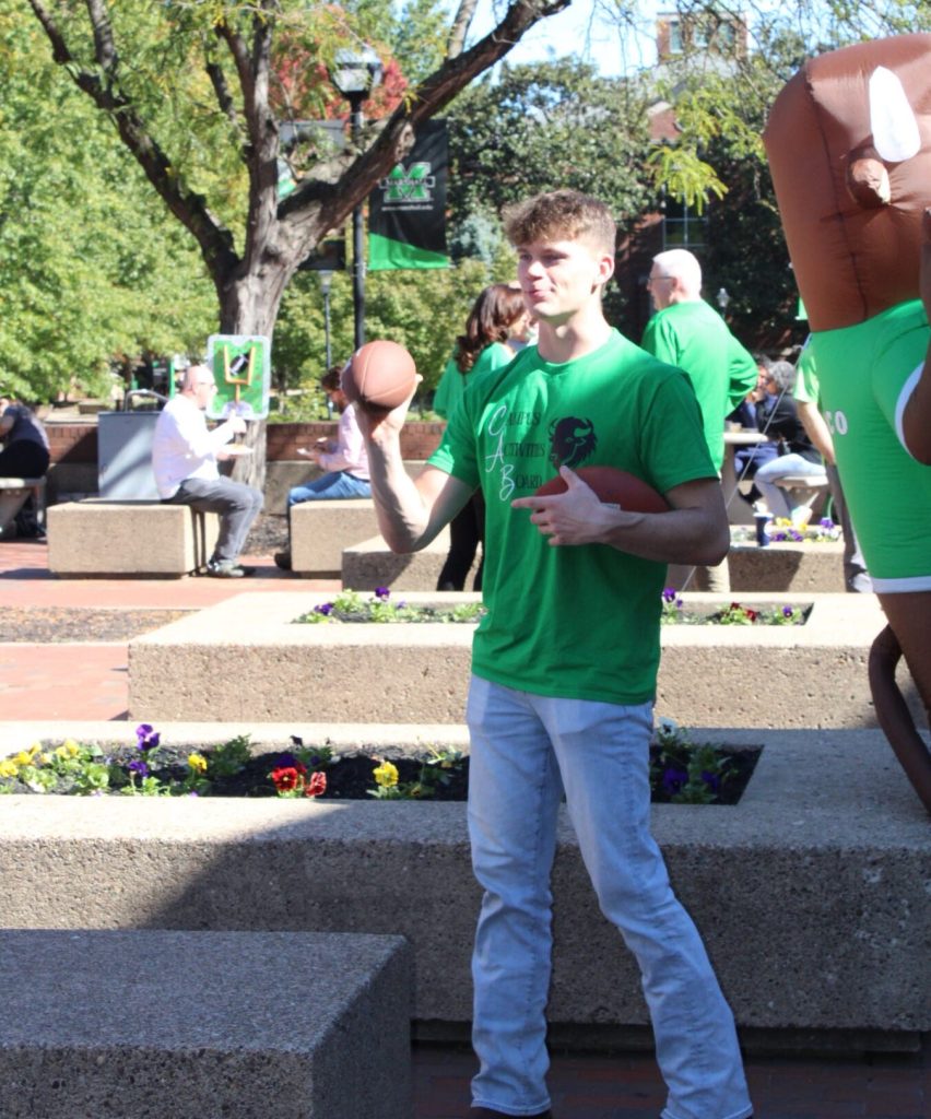 Jakob Tipton throws a football on Marshall University's Memorial Student Center Plaza