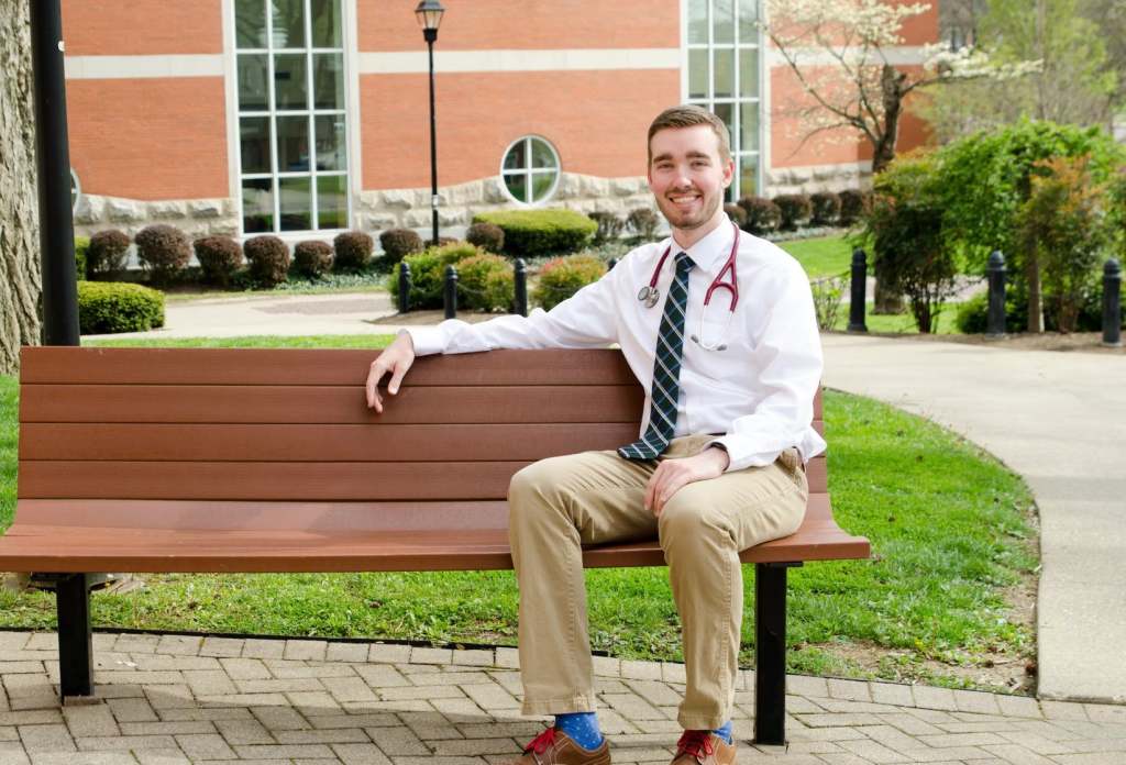 Nathan Welch sitting on a bench outside Old Main