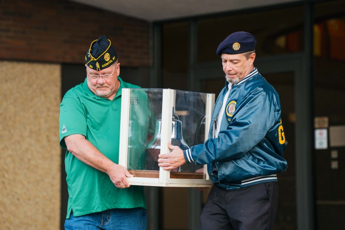 Members of the American Legion carry the USS John Marshall’s bell out of Marshall University's Memorial Student Center for its journey to San Antonio, Texas.
