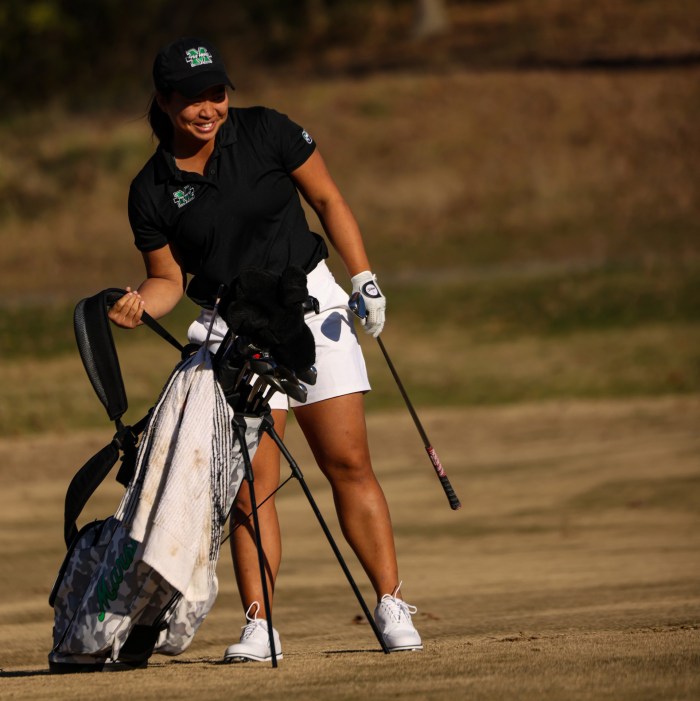 Hanna Shrout wears Marshall attire as she plays golf