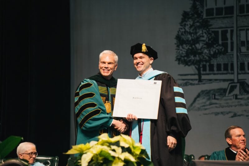 President Smith handing a student a degree at commencement