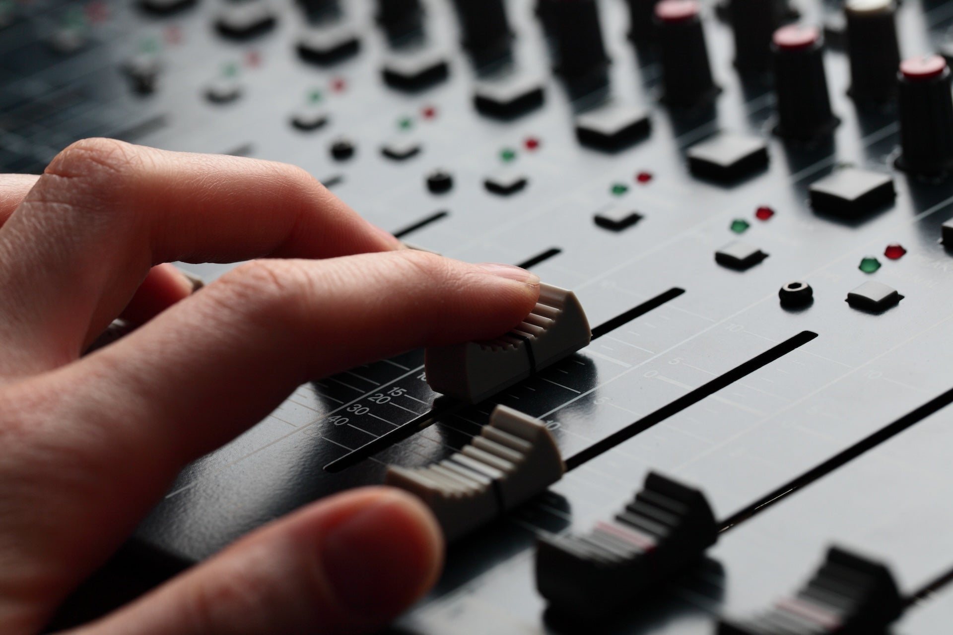 Image of hand on audio board sliders