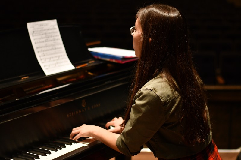 Image of a female student playing a piano.