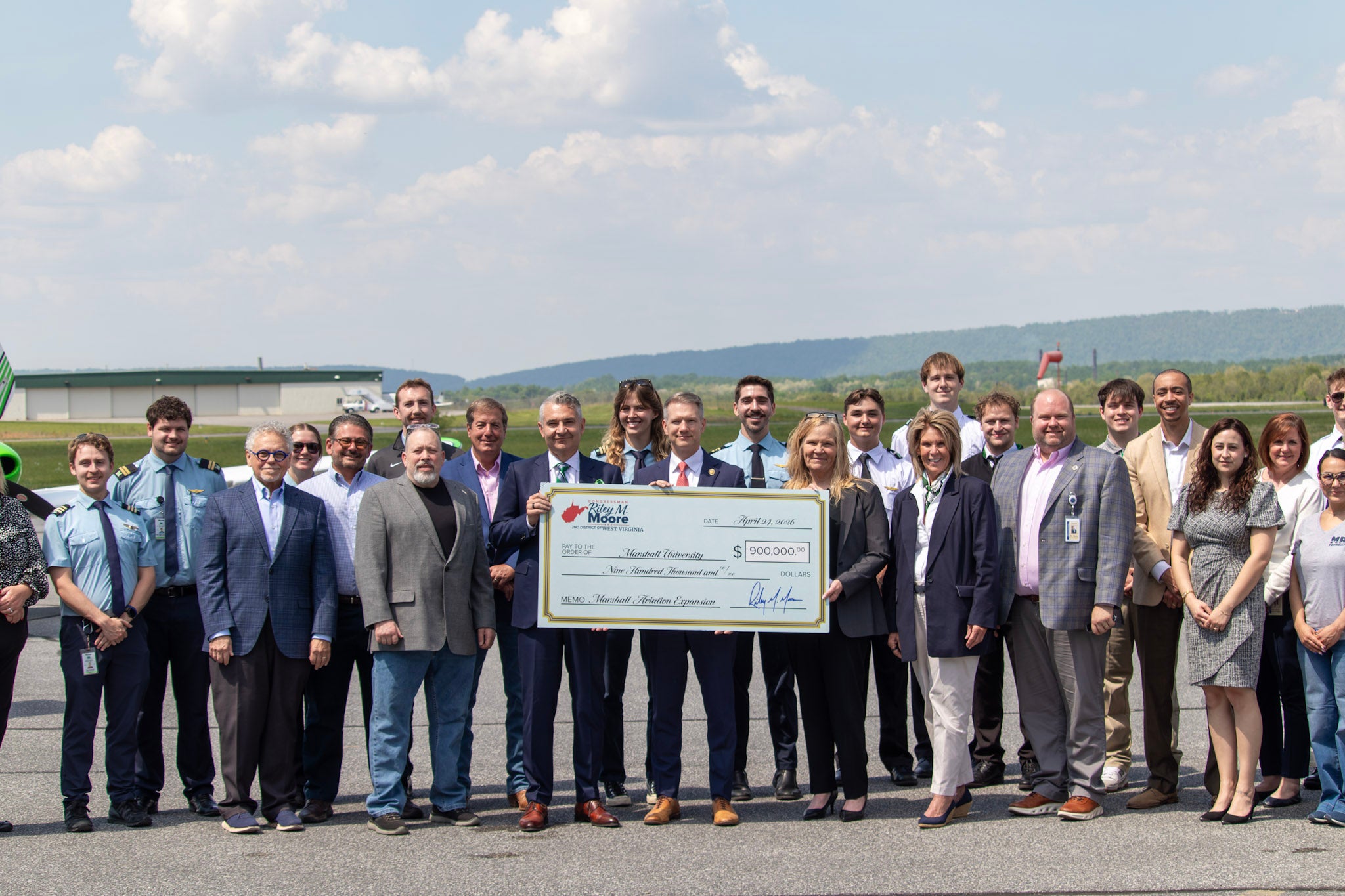 Group of people holding oversized check.