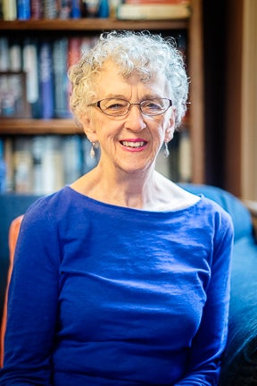 Woman with grey hair and royal blue shirt.