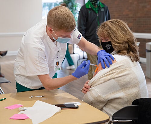 Nursing student giving vaccination