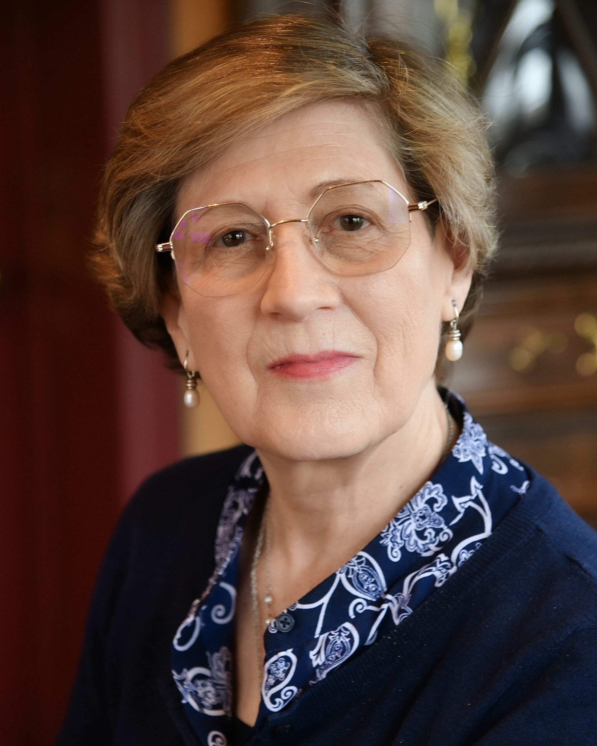Woman in navy blouse with glasses