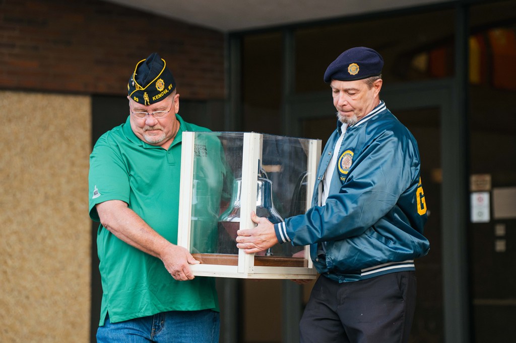 Members of the American Legion carry the USS John Marshall’s bell out of Marshall University's Memorial Student Center for its journey to San Antonio, Texas.