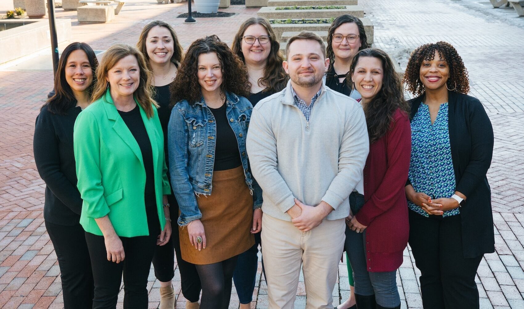 Marshall Online staff group photo, 9 people smiling outside