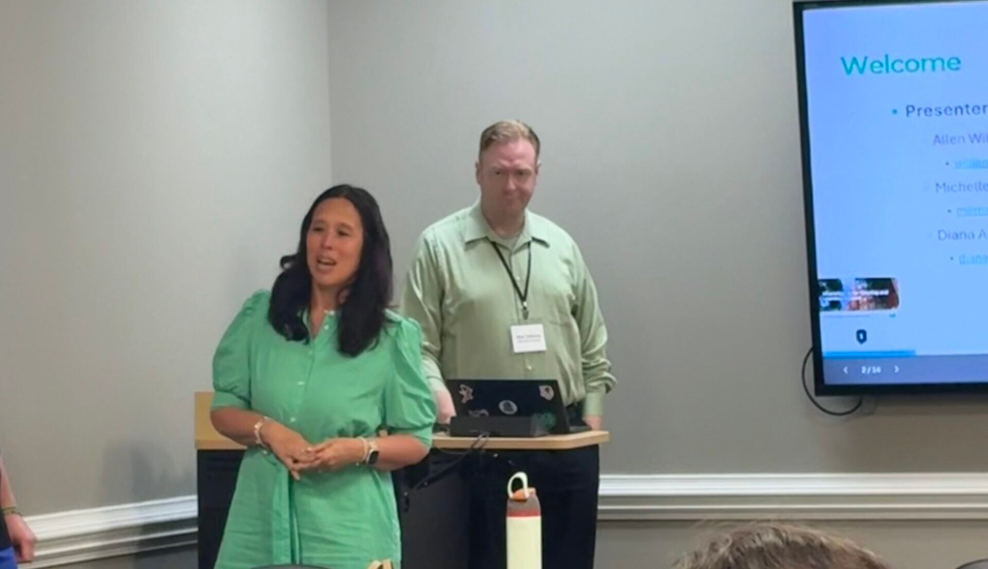 woman in green dress presenting to a room