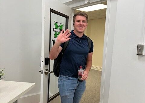 man waving in doorway