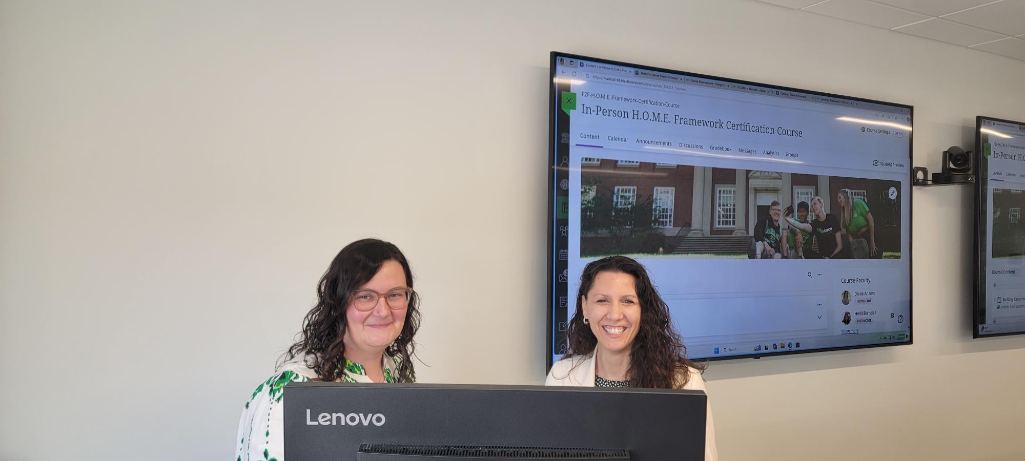 two women smiling in front of a presentation