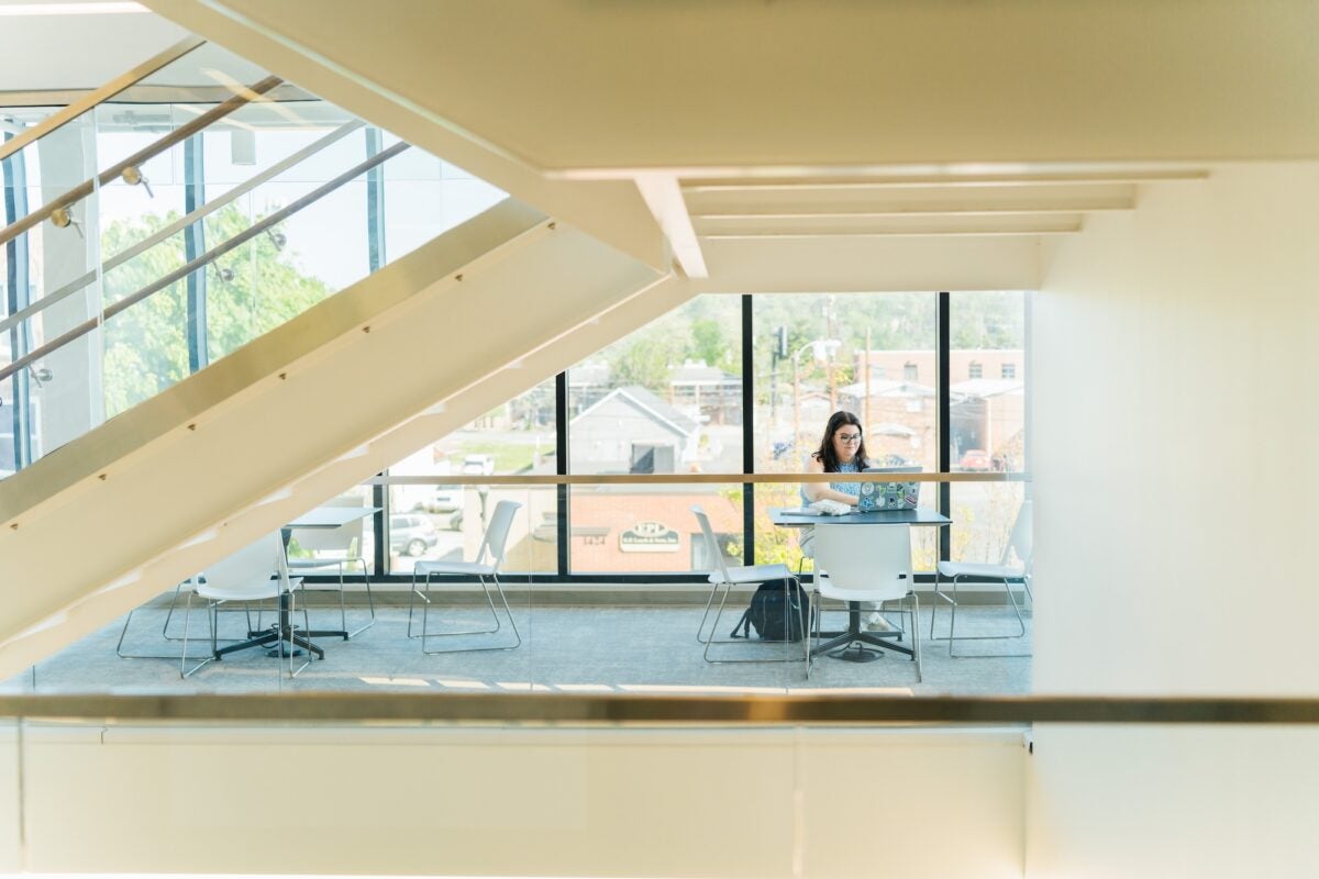student working on a laptop in the College of Business building