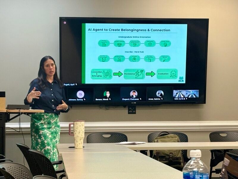 A presenter speaks beside a Marshall Online slide titled 