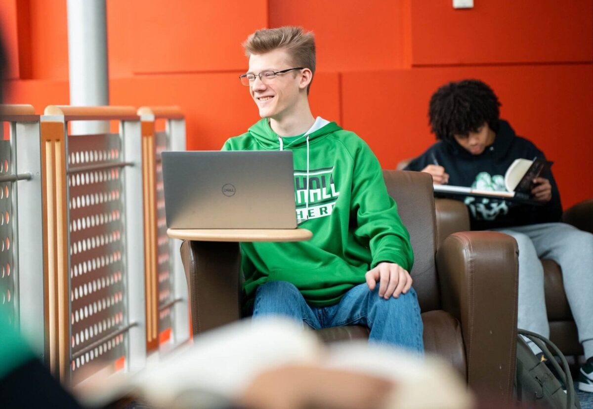 student working on a laptop in the library