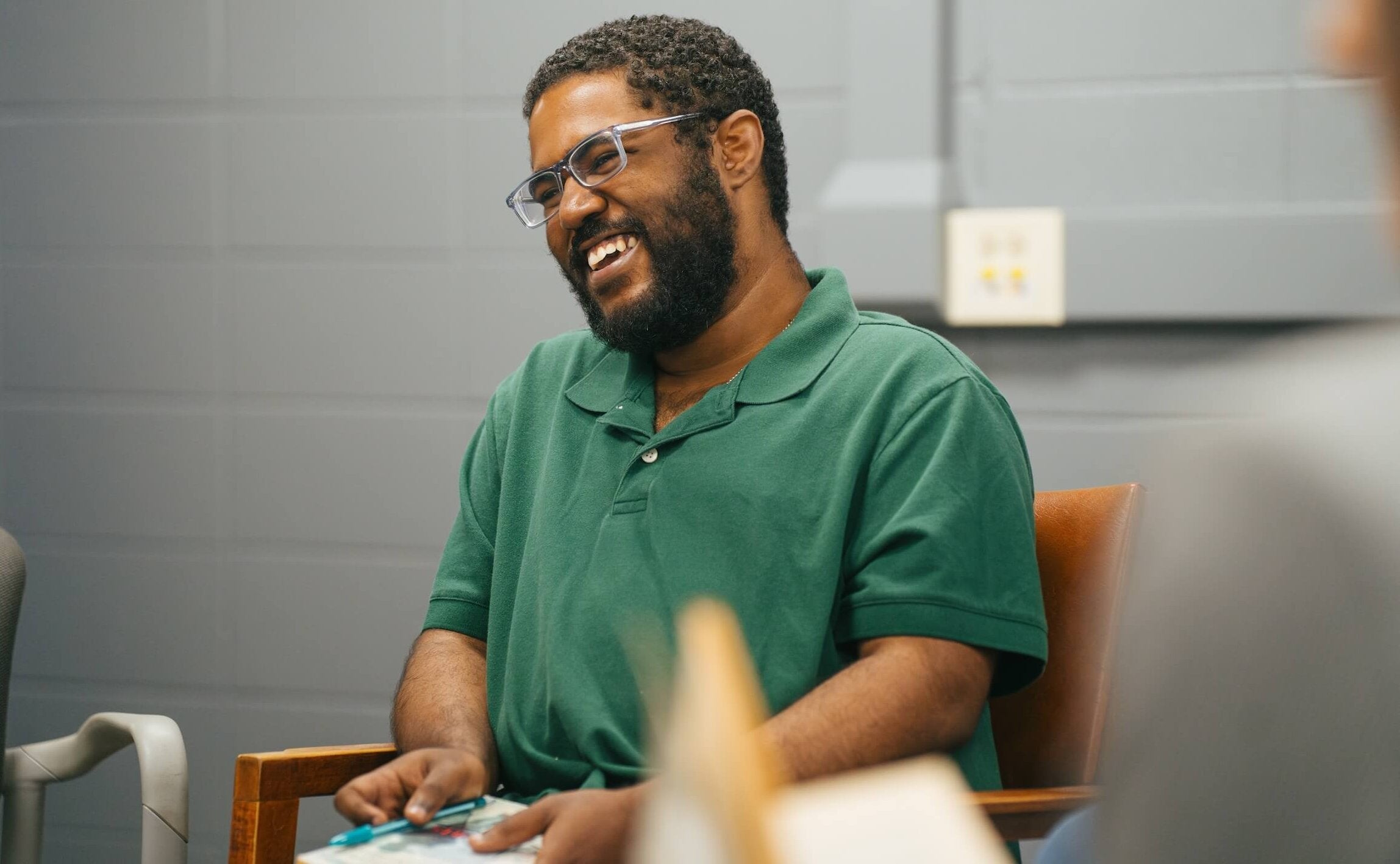 student in a green shirt smiling