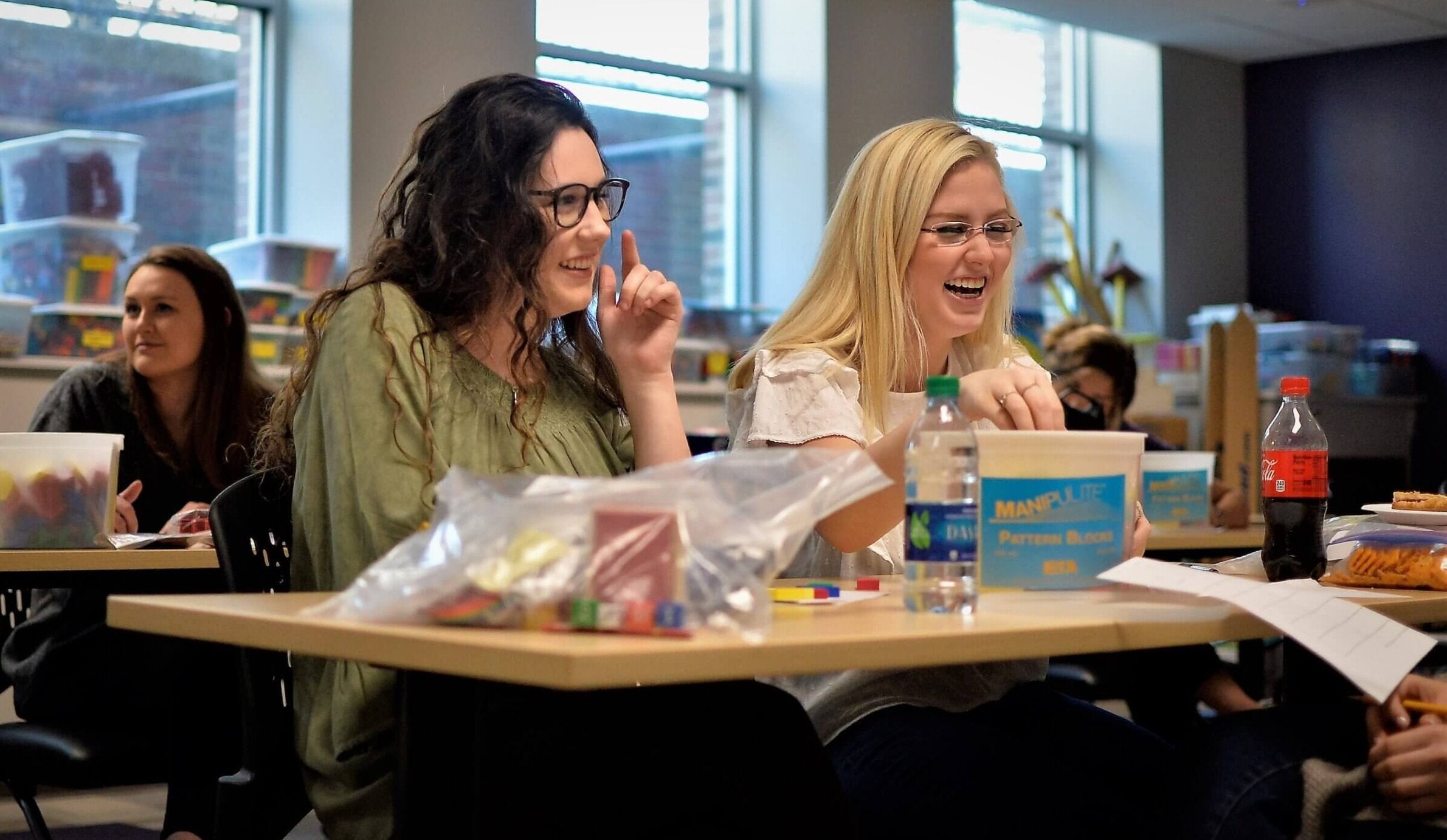 two students sitting at a table laughing
