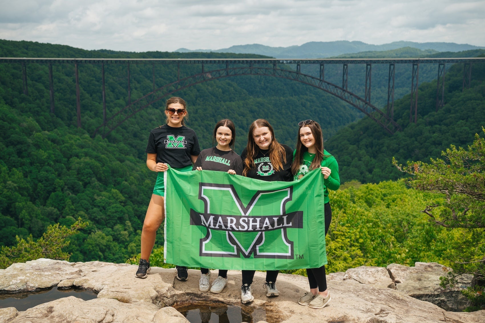 four Marshall students with a Marshall flag at the New River Gorge