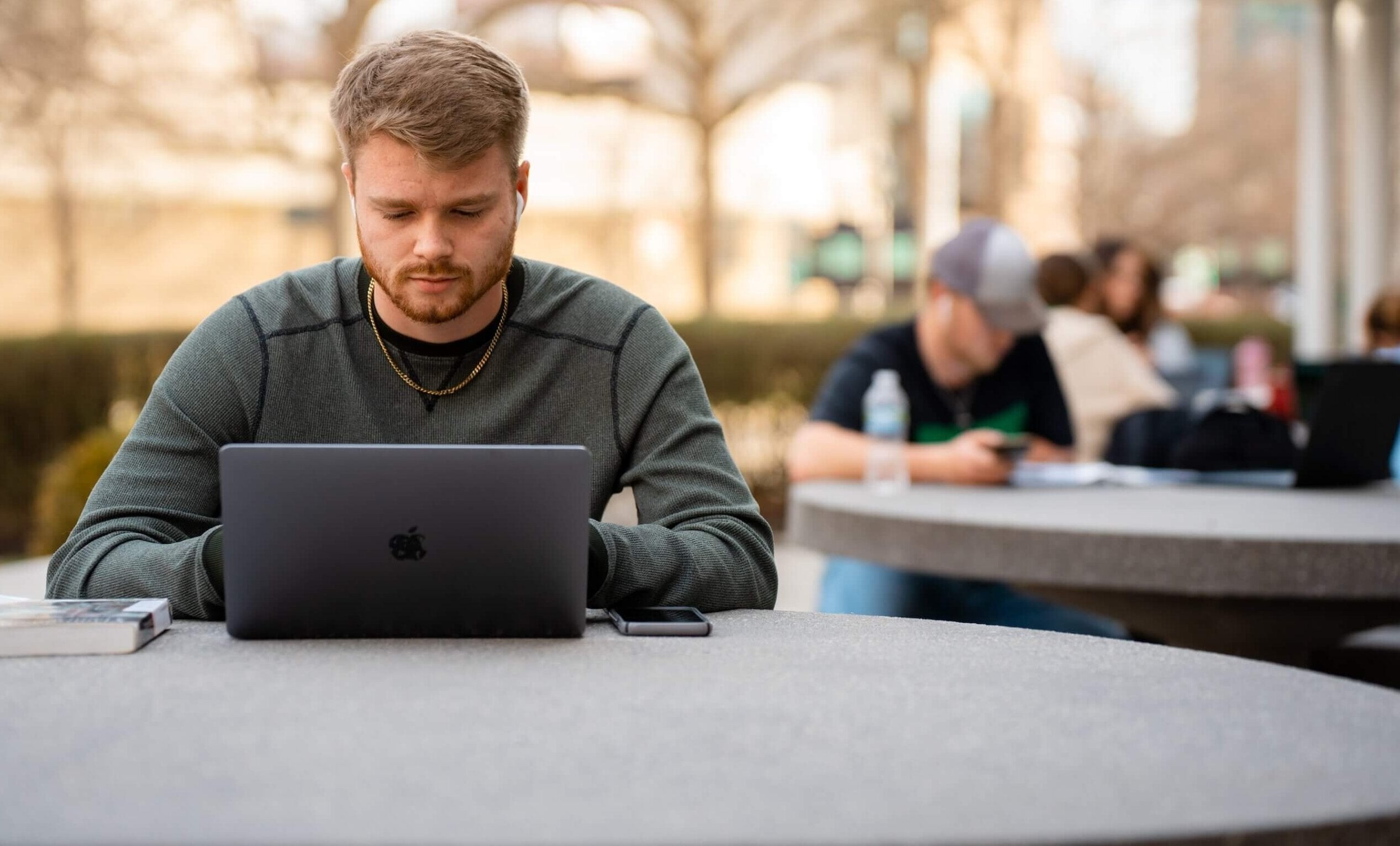 student working on a laptop outside
