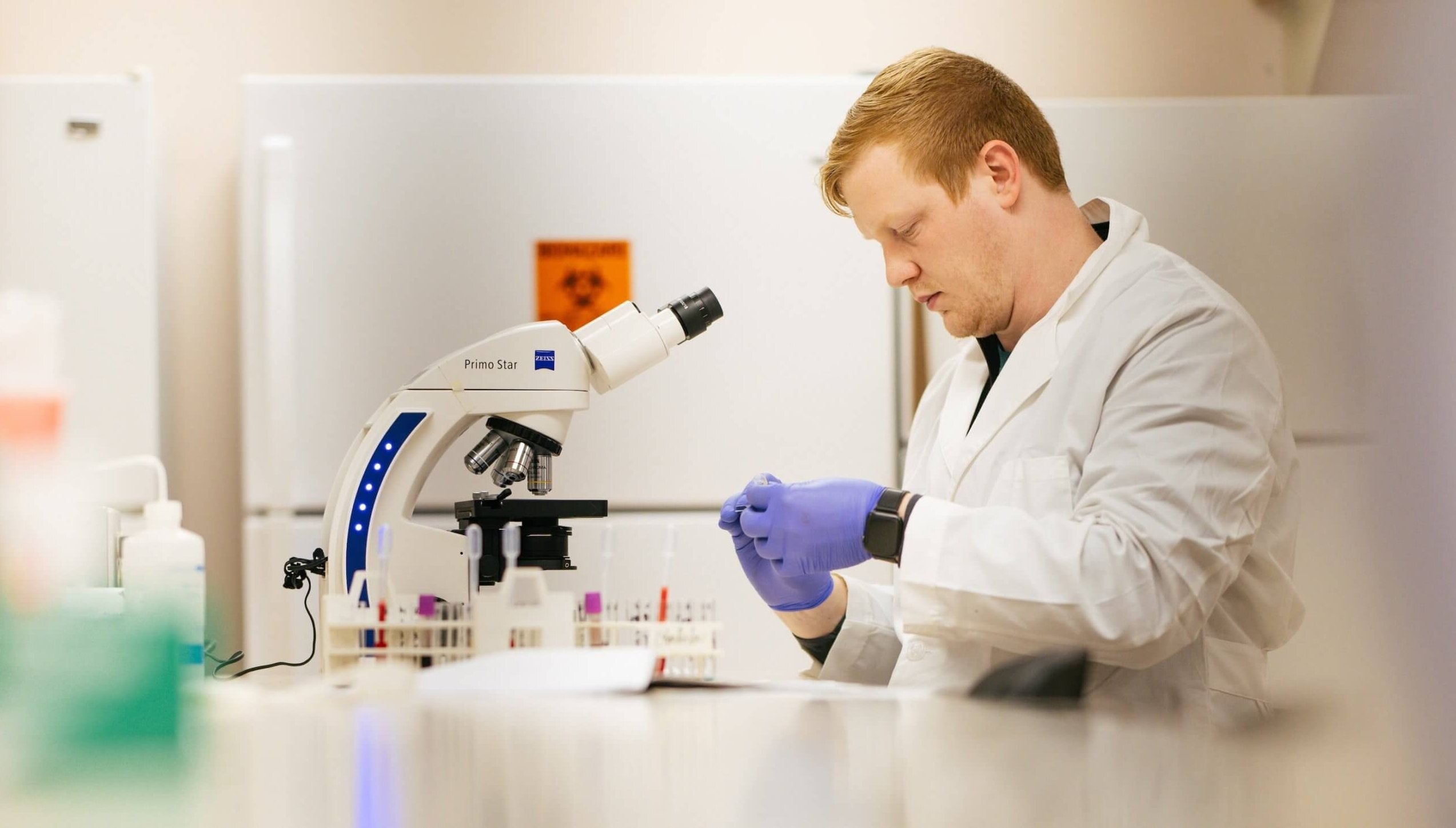 student working in lab at a microscope