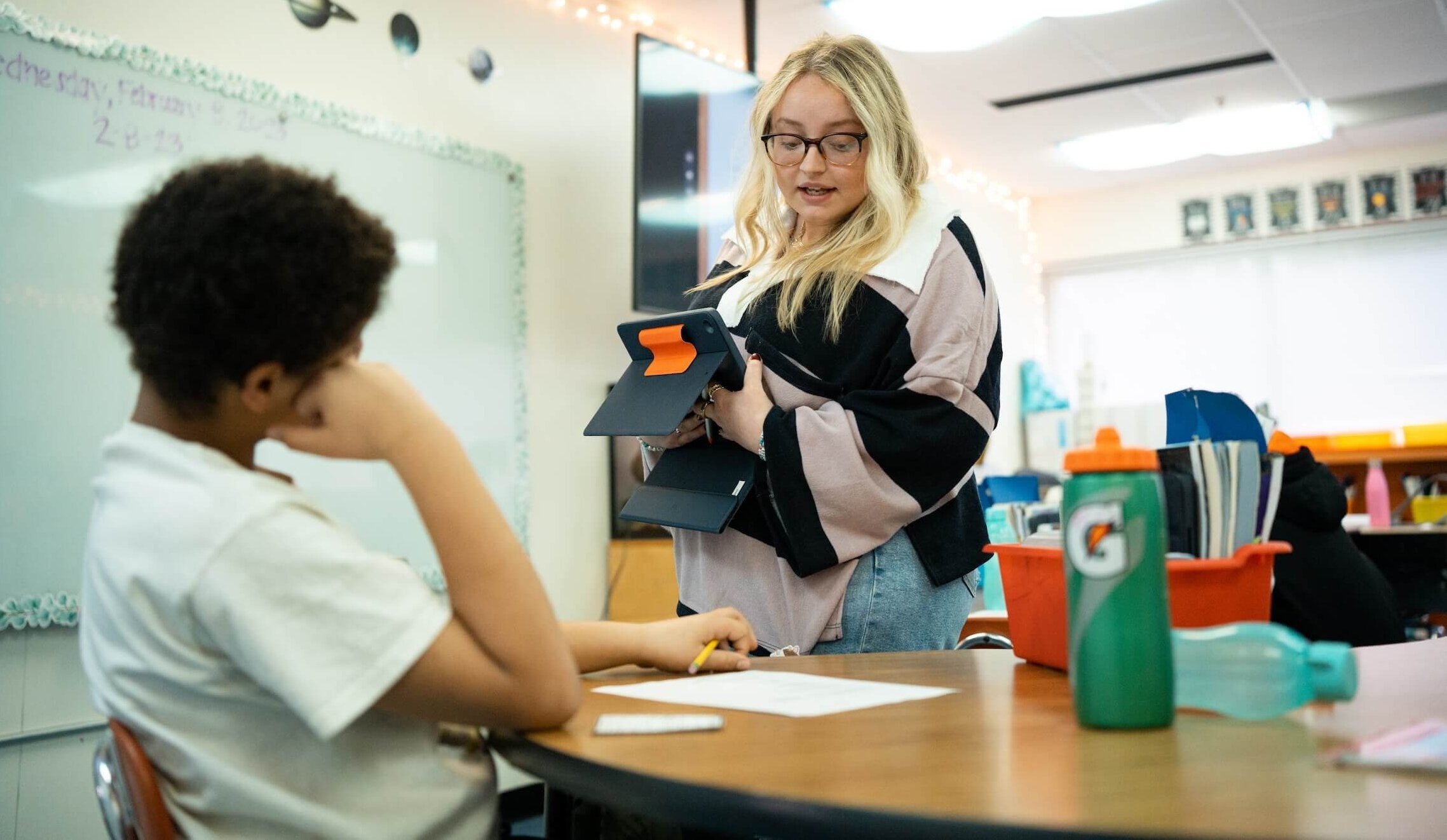 teacher teaching a student in a classroom