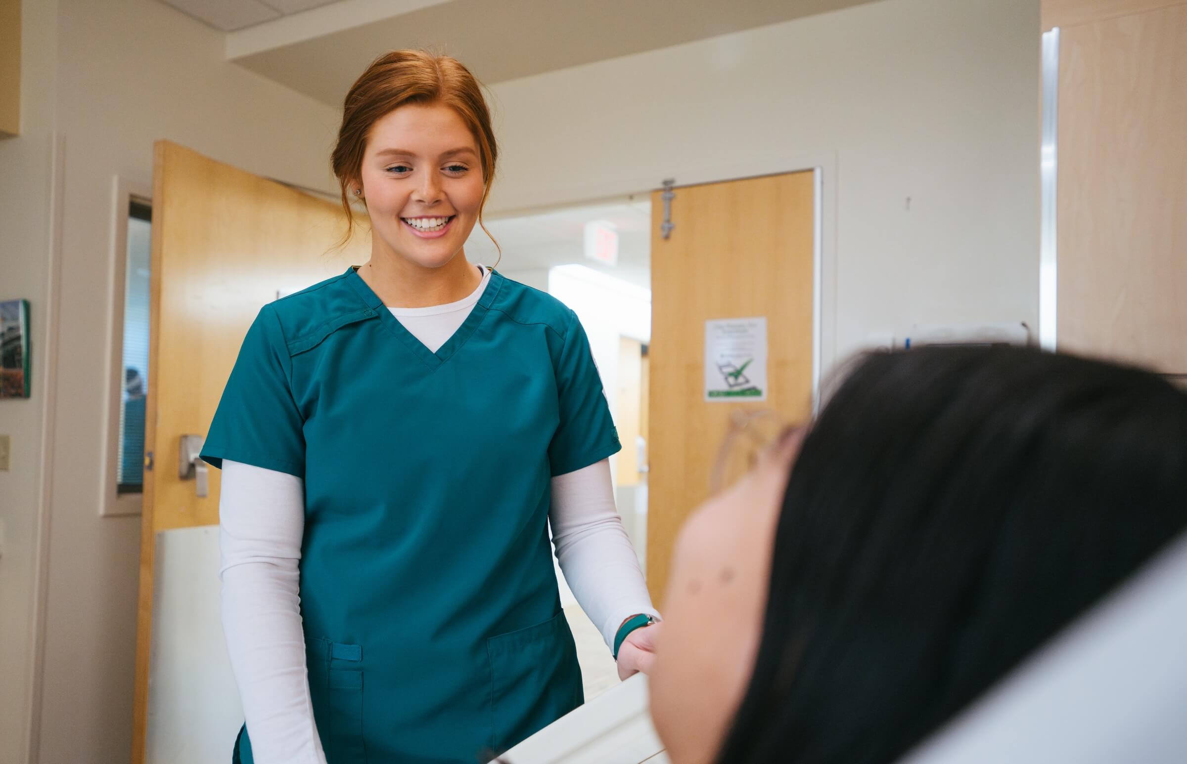 Nursing student helping a patient