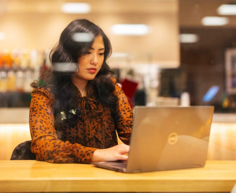 student working inside on a laptop at Starbucks