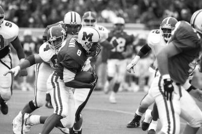 football players running with the ball in black & white