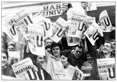 people celebrating Marshall becoming a university with Parthenon newspapers