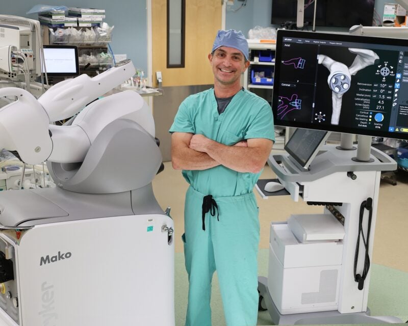 Dr. Jasko standing in front of Mako robot