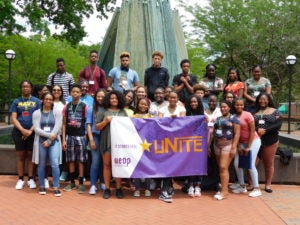 image of group of student with unite sign and in front of the fountain