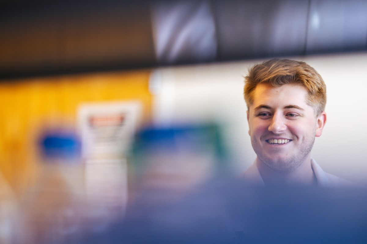 pharmacy student working in a lab and smiling