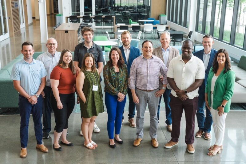 large group of entrepreneurs smiling at the camera at the School of Business