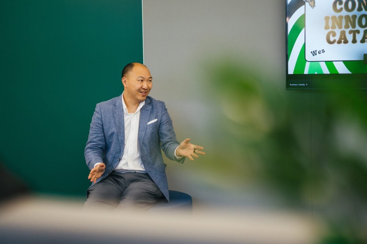 Ben Eng presenting at the front of a conference room