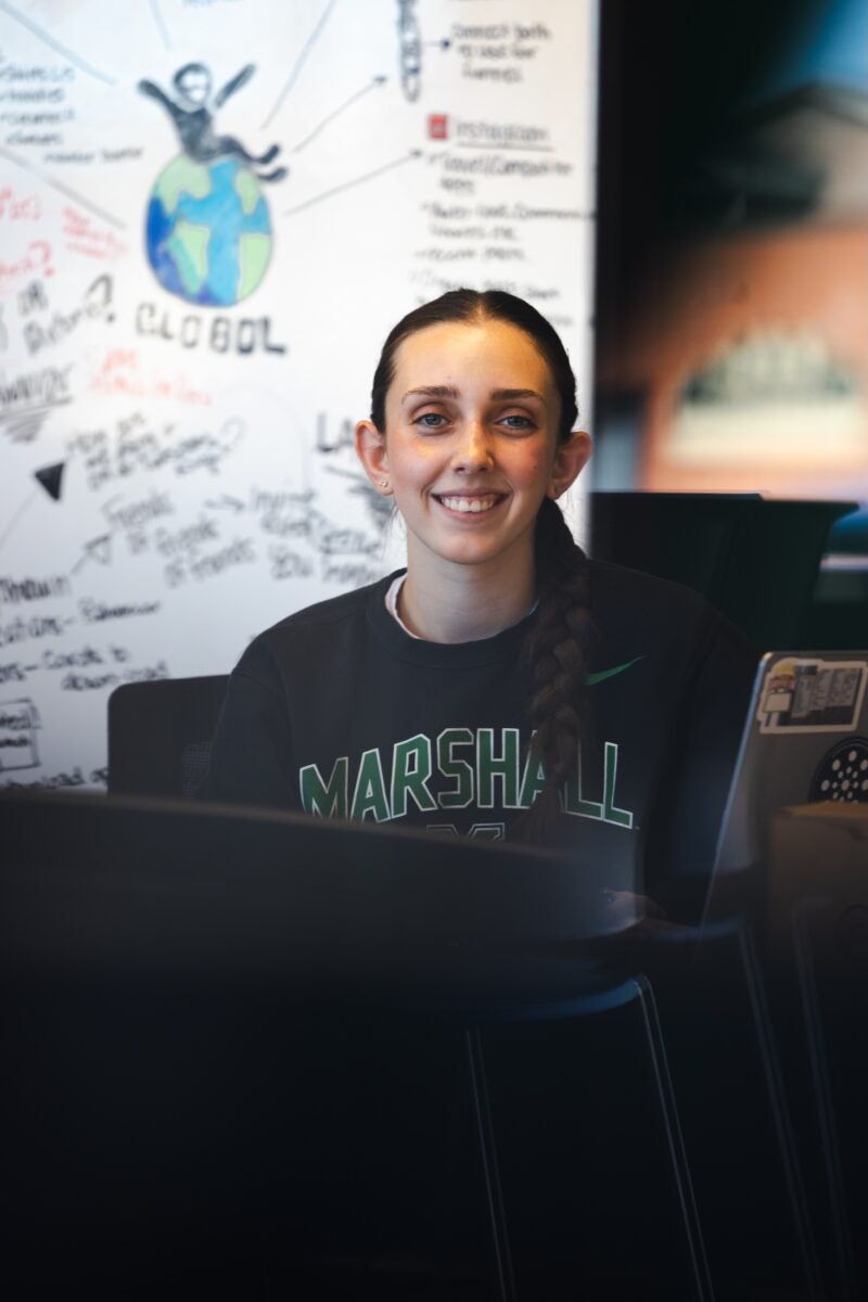 student working int he iCenter and smiling at the camera