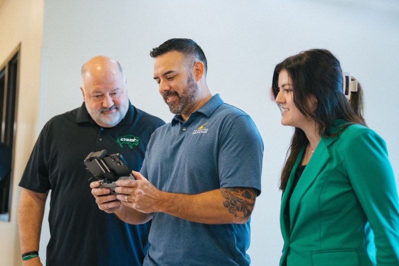 three people exploring how a drone is controlled