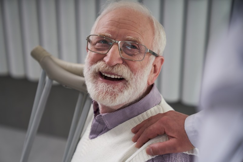Cheerful elderly man smiling widely looking grateful for his doctors medical attention and good care